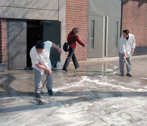 Workers washing down the sidewalk near 10th Avenue.